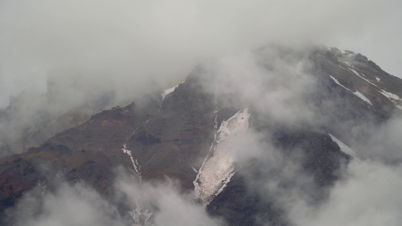 堪察加半岛的科里亚克火山峰顶的壮观景象。在多云天气形成云雾的岩石山脉的时间推移视图视频素材