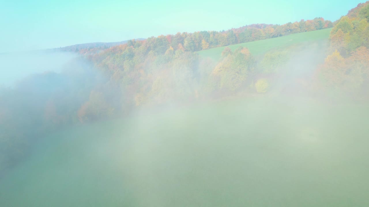 空中:山丘的景色在秋日晨雾中透出绚丽的色彩视频素材