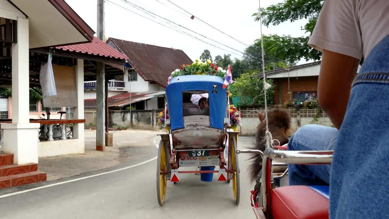 在泰国南邦的Phrathat Lampang Luang寺庙，亚洲家庭游客乘坐马车视频素材