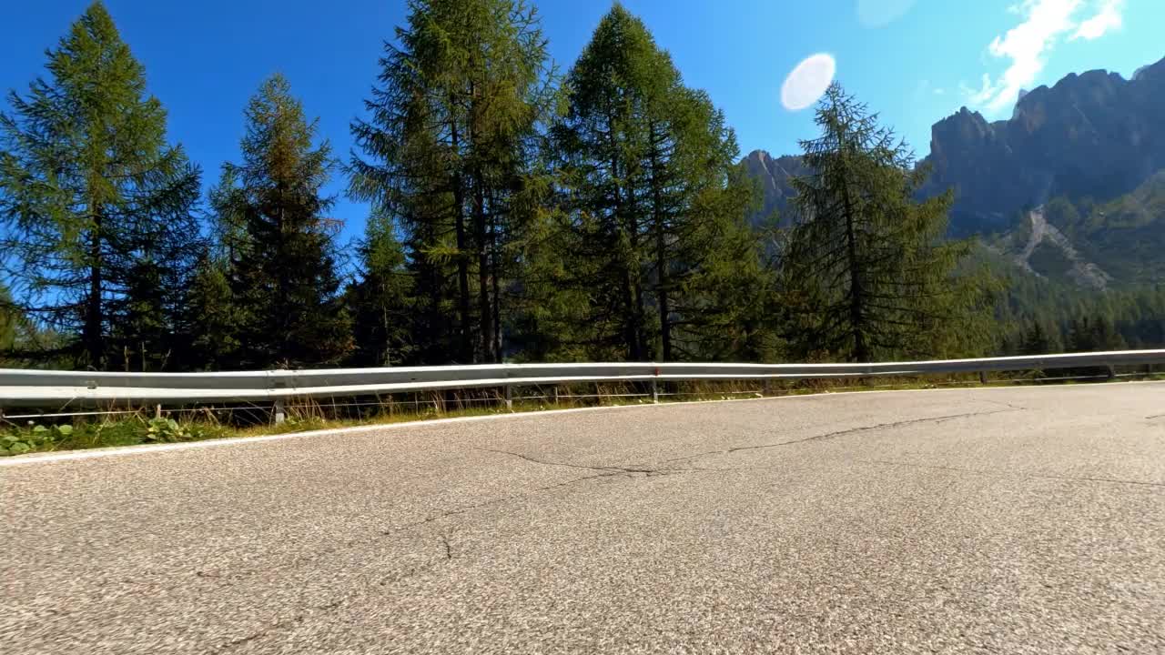 行驶在蜿蜒的山路上，四周绿树成荫，山峰高耸视频素材