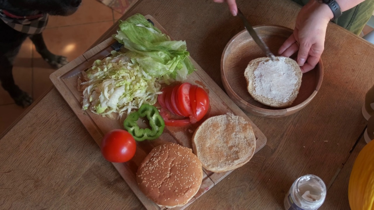 厨师正在准备一个美味的素食汉堡，加入素食蛋黄酱的4K慢镜头视频素材