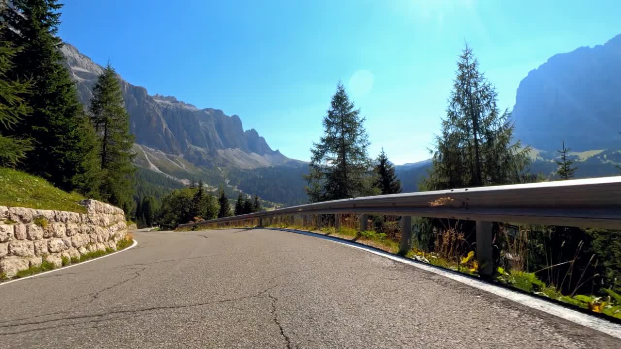 在一个阳光明媚的日子，开着跑车在山间公路上穿越如画的风景视频素材