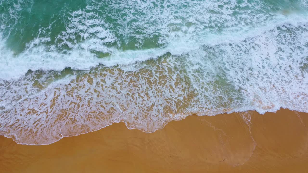 美丽的海浪和热带岛屿上的白色沙滩。从无人机俯瞰，沙滩背景上蓝色海洋的软波。放松和度假旅行的概念。视频素材