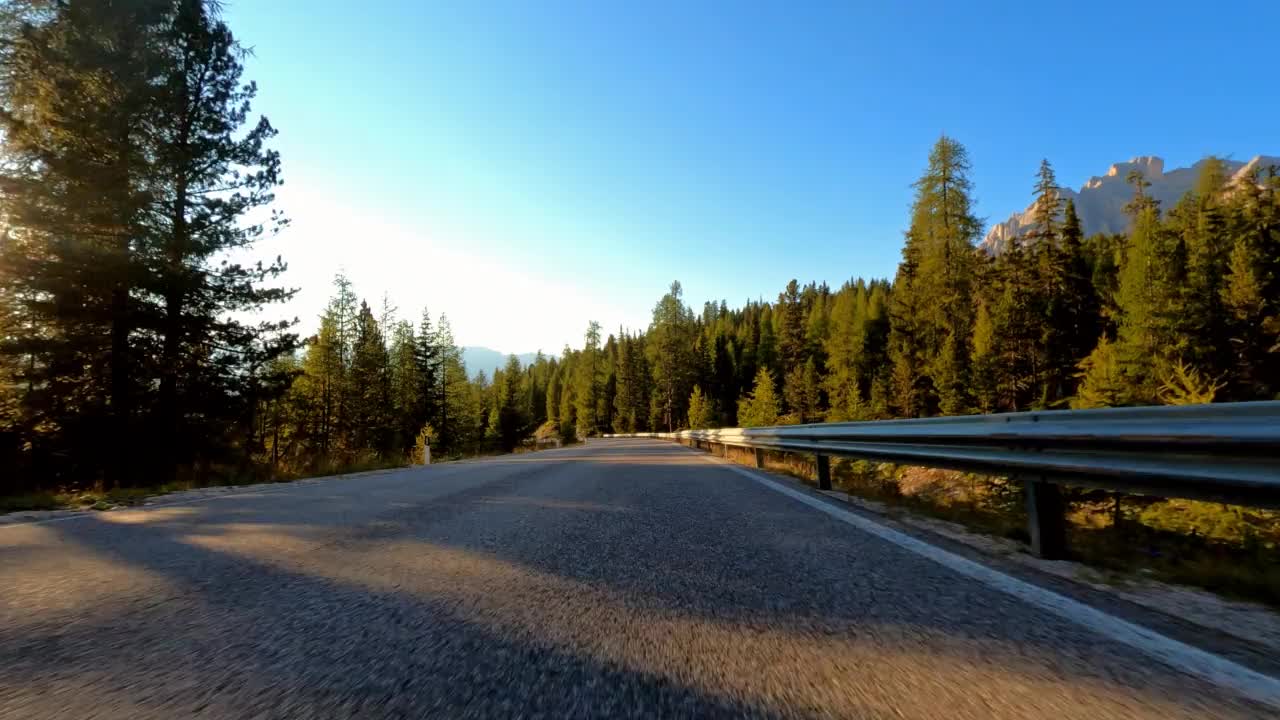 汽车旅行在一个空旷的风景曲径在山口在日出视频素材