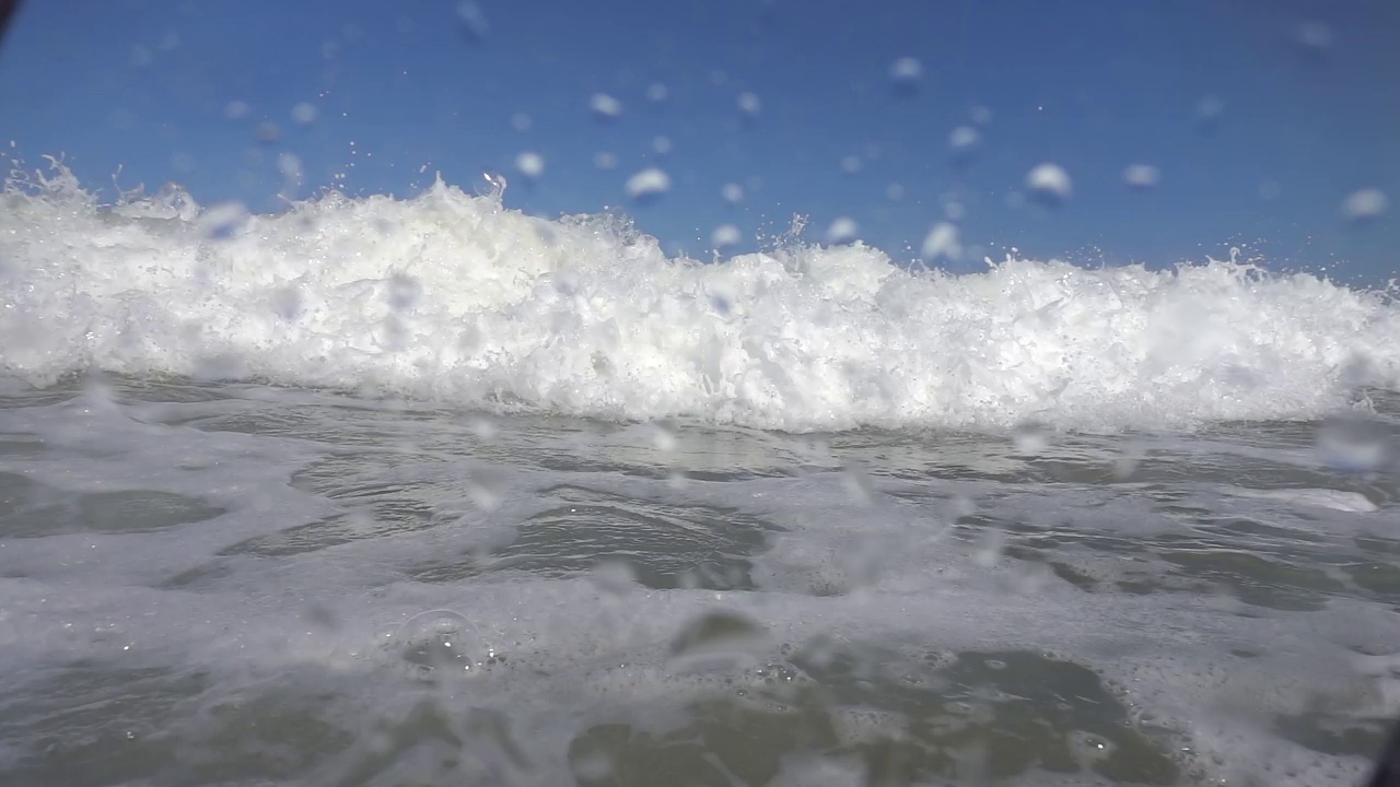 摄像机被淹没在水下和海面上，在溺水的大海中。美丽的光线折射在海浪表面，潜水，浮潜。视频素材