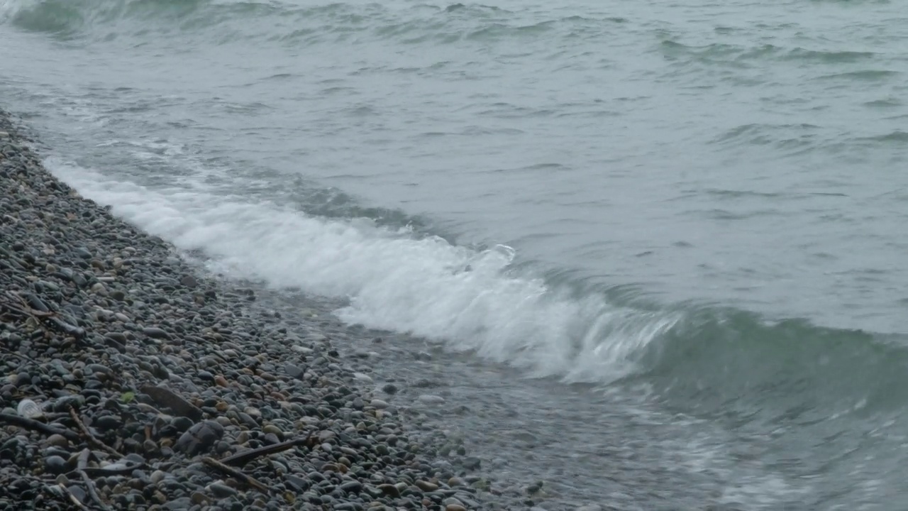 暴雨来临前，汹涌的海水和海浪拍打着海岸。波浪拍打着海岸，溅起水花。海的看法。水边，海岸线。海洋运输的概念，海洋动植物。安静的冲浪。美存在于自然之中。视频素材