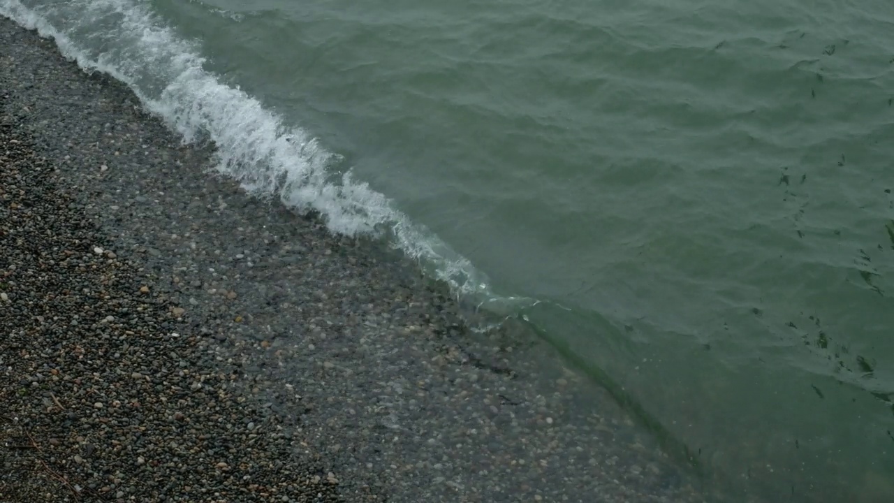 暴雨来临前，汹涌的海水和海浪拍打着海岸。波浪拍打着海岸，溅起水花。海的看法。水边，海岸线。海洋运输的概念，海洋动植物。安静的冲浪。美存在于自然之中。视频素材