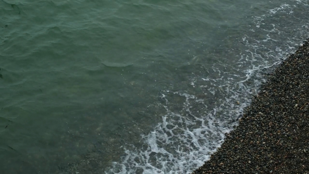 暴雨来临前，汹涌的海水和海浪拍打着海岸。波浪拍打着海岸，溅起水花。海的看法。水边，海岸线。海洋运输的概念，海洋动植物。安静的冲浪。美存在于自然之中。视频素材