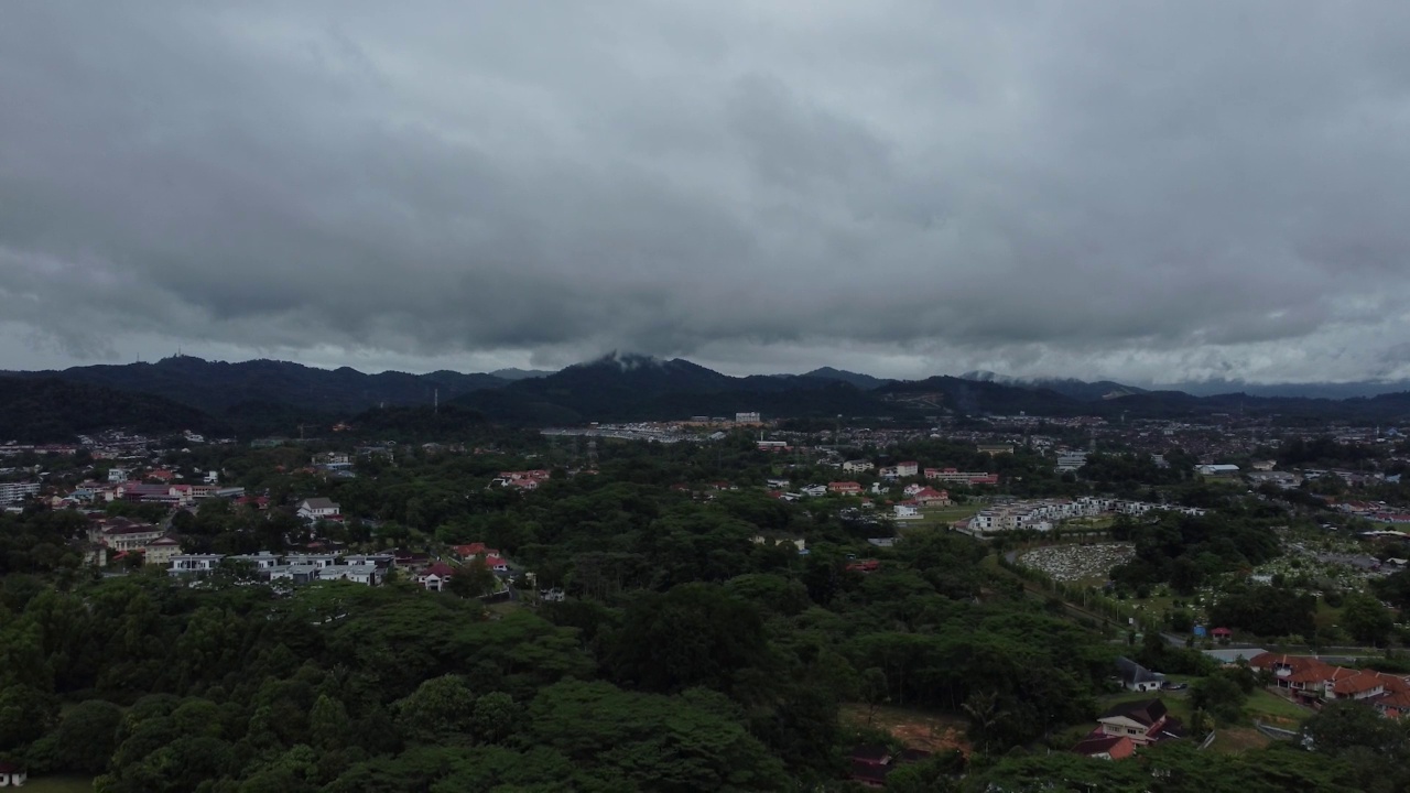 在阴天俯瞰青山山坡上的乡村房屋和种植园视频素材