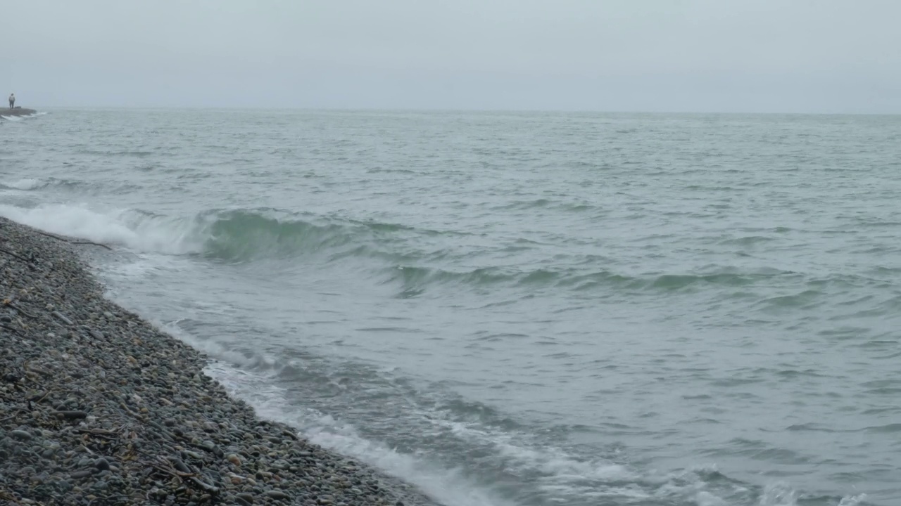 暴雨来临前，汹涌的海水和海浪拍打着海岸。波浪拍打着海岸，溅起水花。海的看法。水边，海岸线。海洋运输的概念，海洋动植物。安静的冲浪。美存在于自然之中。视频素材