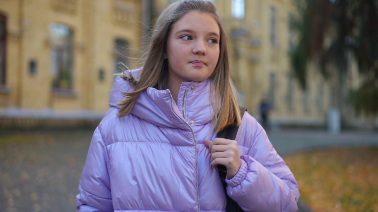 迷人少女的肖像挂双肩包走在秋天的校园离开。聪明积极的白人女孩在课后四处闲逛。教育和生活方式。视频素材