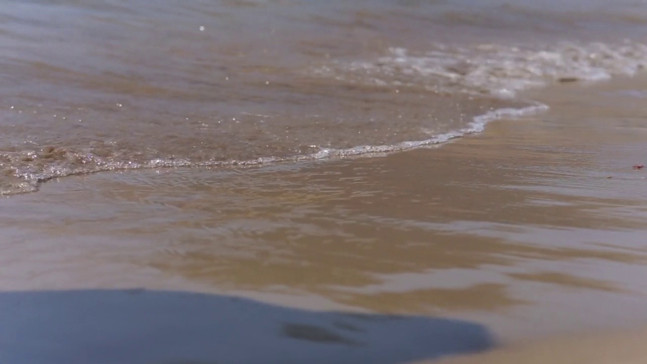 海水背景。近距离观看海水泡沫和潮湿的沙滩。视频素材