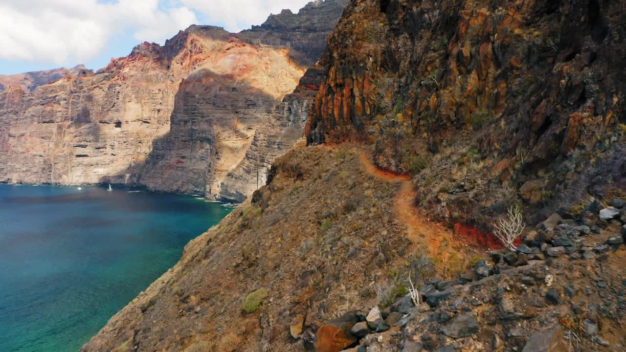 沿着火山岩的狭窄而危险的小路。惊人的海浪拍打着巨大的石岸。加那利群岛。特内里费。洛杉矶Gigantes悬崖。鸟瞰图。假期,假期时间。视频素材