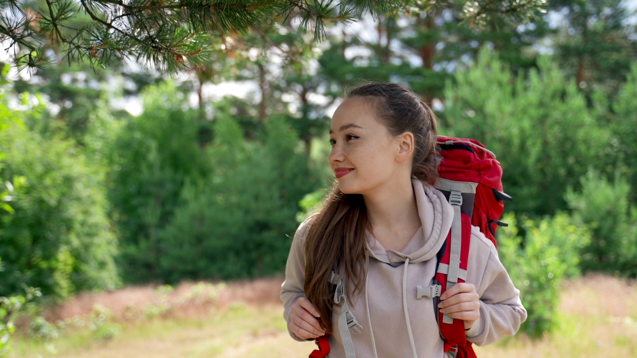 棕色头发的女人走在林间空地上享受阳光明媚的日子视频素材