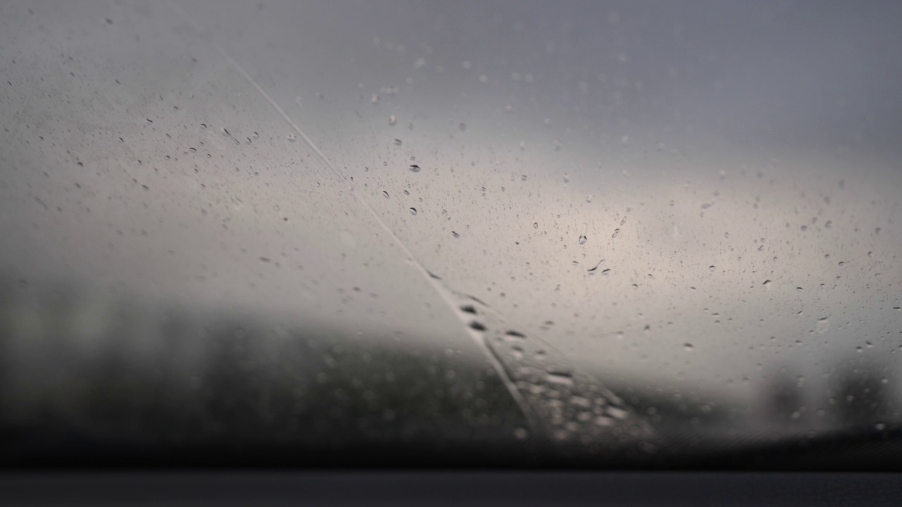 雨刷在汽车上工作，用来清洗挡风玻璃上的雨点视频素材