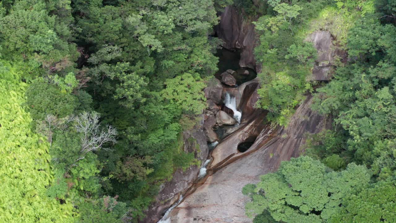 4k广角无人机拍摄的原始雨林瀑布，缓慢拉回。屋久日本视频素材