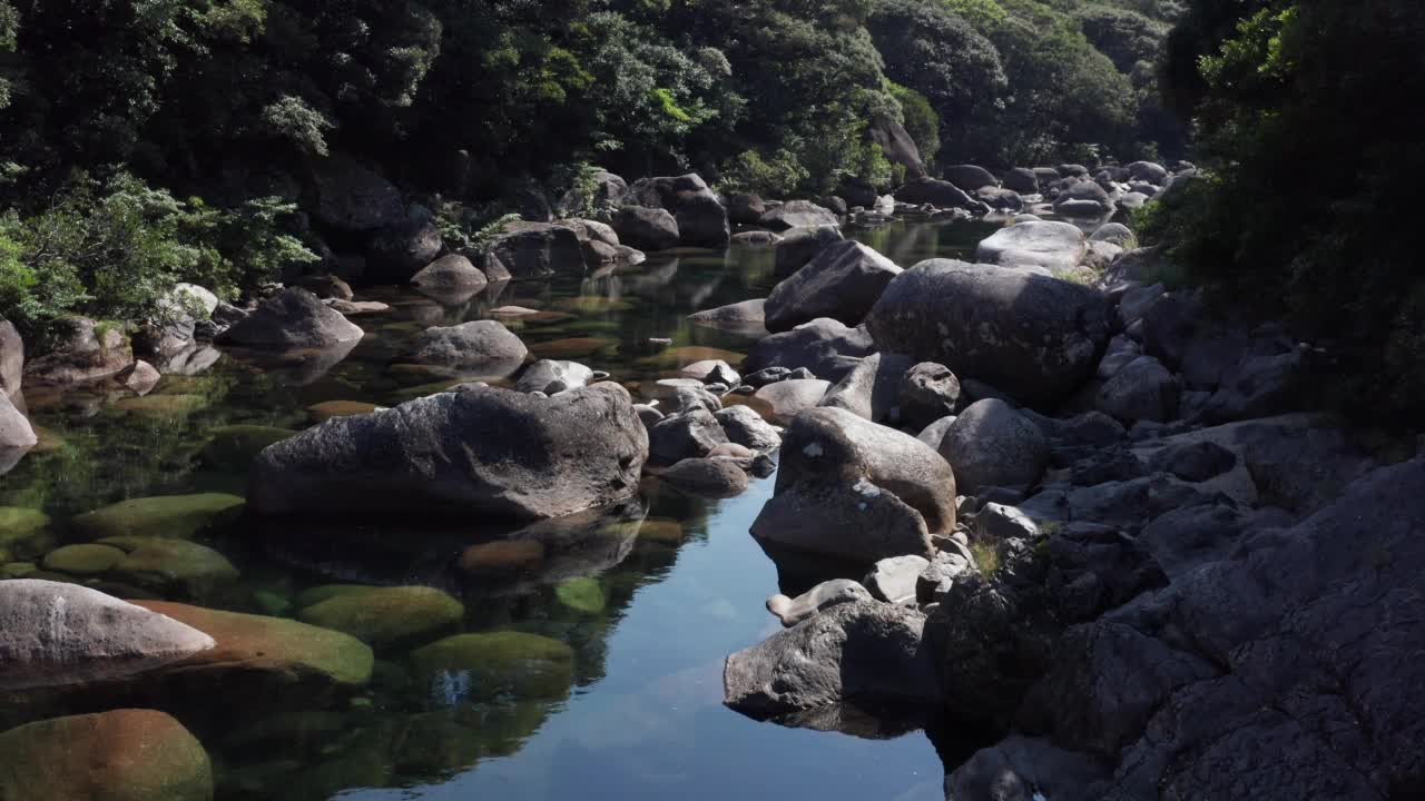 在日本屋久岛，一架4k无人机飞上了一条有着巨大花岗岩巨石的原始河流。联合国教科文组织世界遗产。视频素材