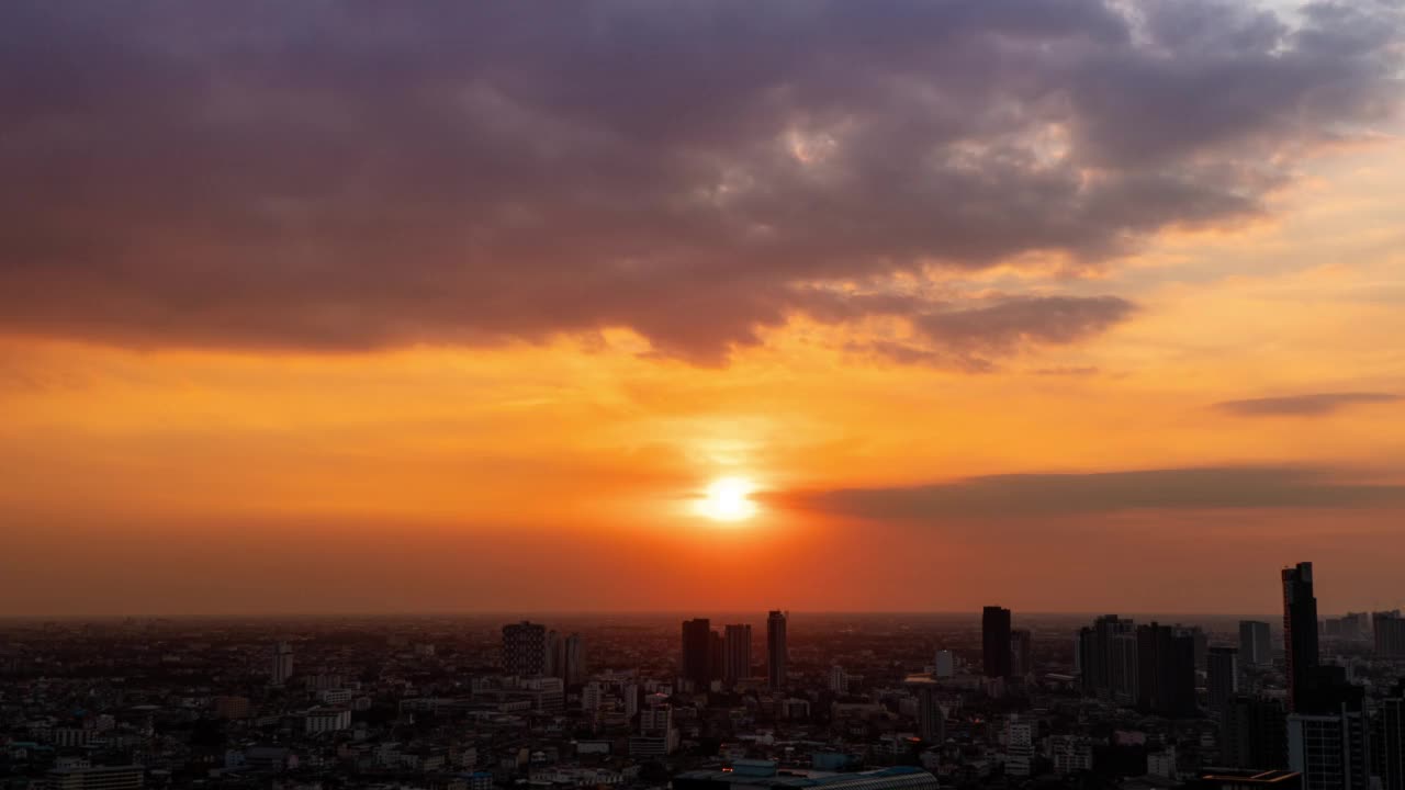 大气明亮的暮色，日落，金色的辉光与云在建筑物，城市景观在泰国曼谷。时间流逝4k天际线在傍晚日落建筑在自然背景。视频下载