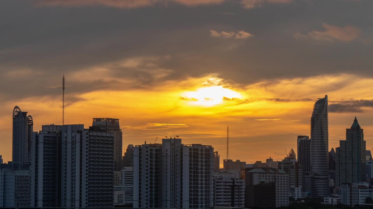 曼谷清晨新一天的风景城市。时光流逝的建筑和城市景观与运动天空云在温暖的橙色日出。视频下载