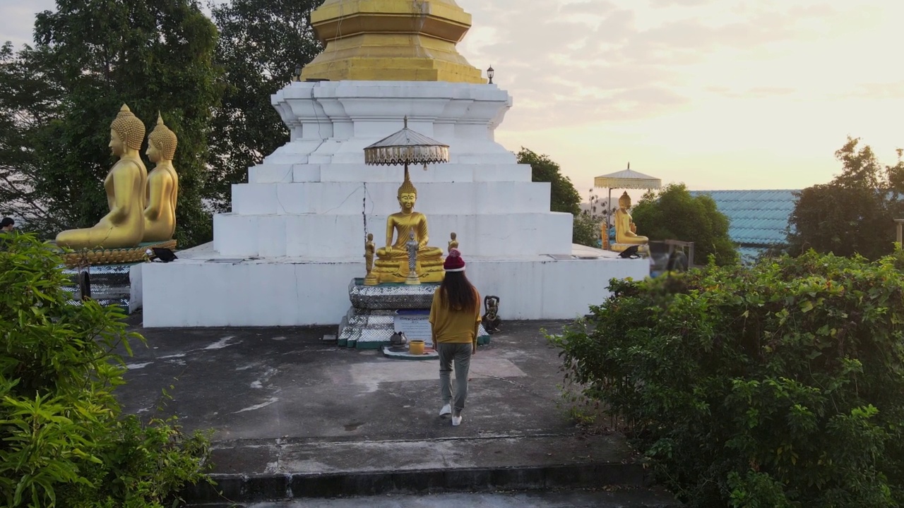 年轻的亚洲旅行家妇女祈祷尊重佛建筑佛塔在Phrae，泰国。视频素材