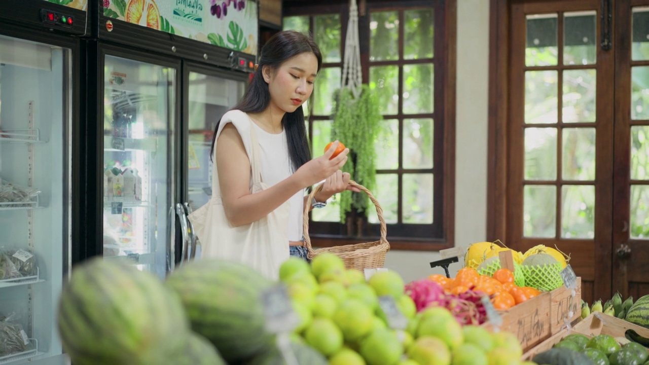 一名妇女买橘子做果汁视频素材