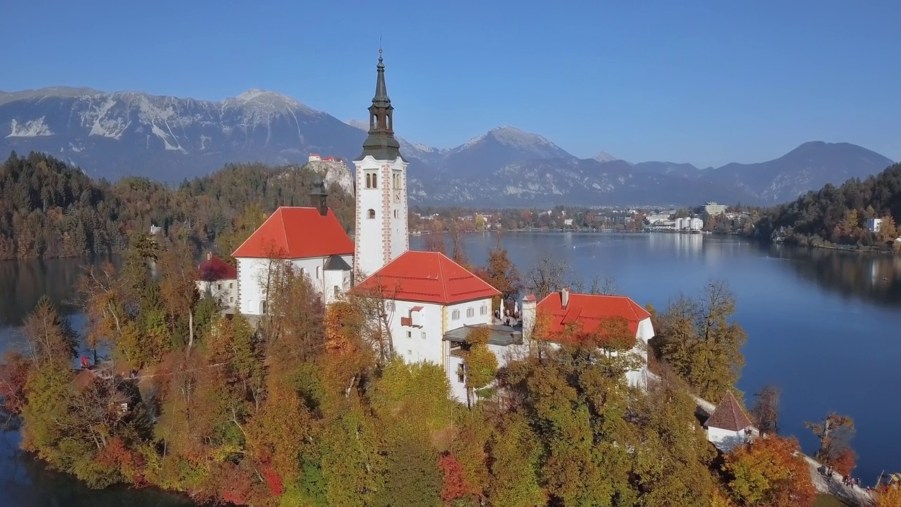 在斯洛文尼亚的布洛德岛(Blejski otok)和圣母升天教堂的朝圣之旅以及在五彩缤纷的秋天森林的布洛德湖上的布洛德。视频素材