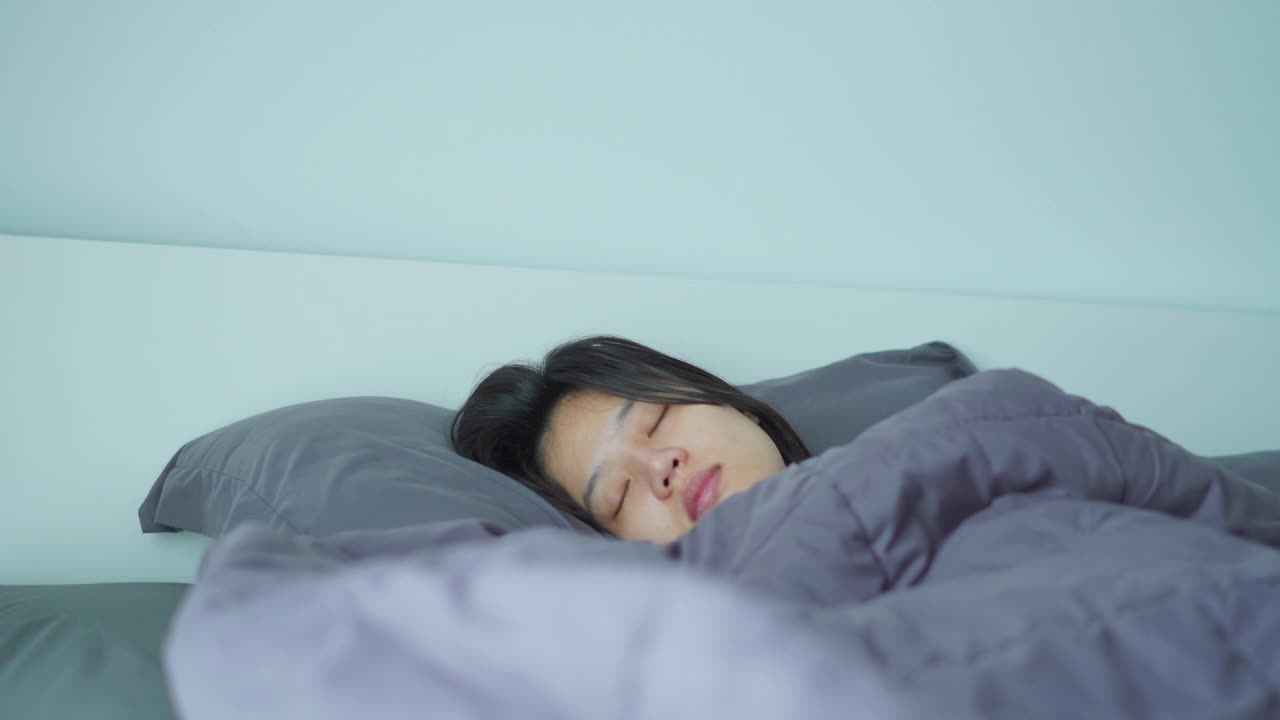 美丽的亚洲女人从她的睡眠在一个阳光明媚的早晨醒来视频素材