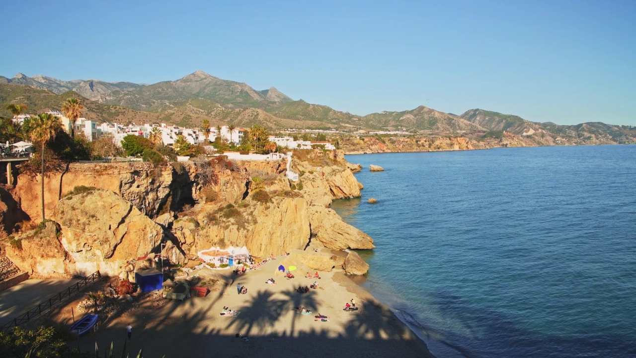 空中无人机查看美丽的海滩在西班牙的地中海海岸在Nerja, Costa Del Sol在安达卢西亚(安达卢西亚)，山脉和蓝色的海洋海水在晴朗的蓝天晴天在欧洲视频素材