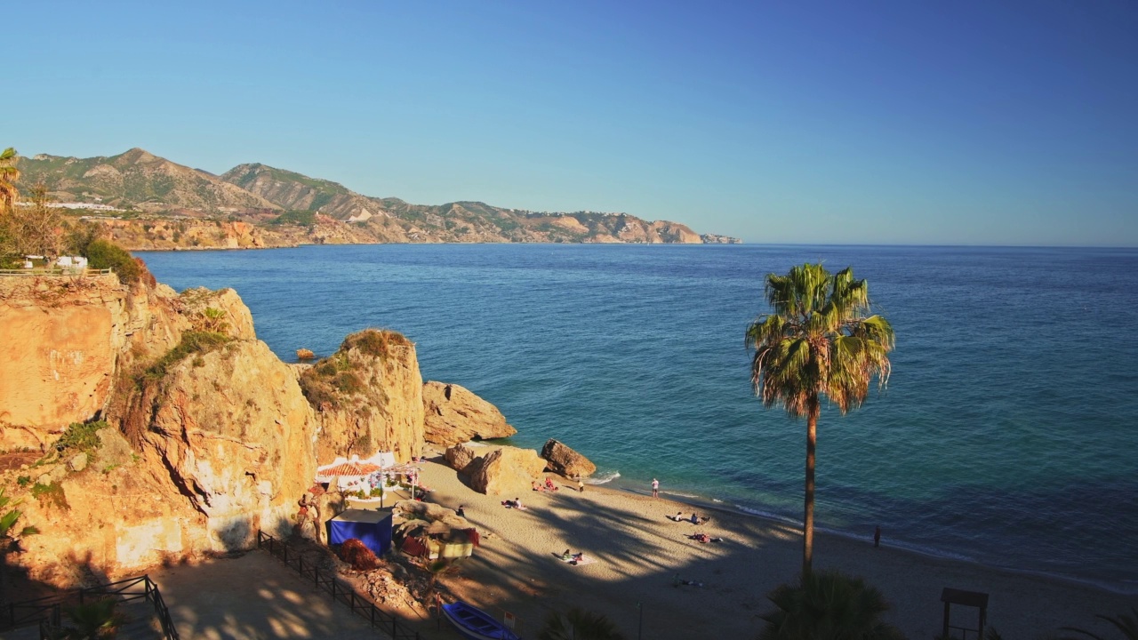 空中无人机查看美丽的海滩在西班牙的地中海海岸在Nerja, Costa Del Sol在安达卢西亚(安达卢西亚)，山脉和蓝色的海洋海水在晴朗的蓝天晴天在欧洲视频素材