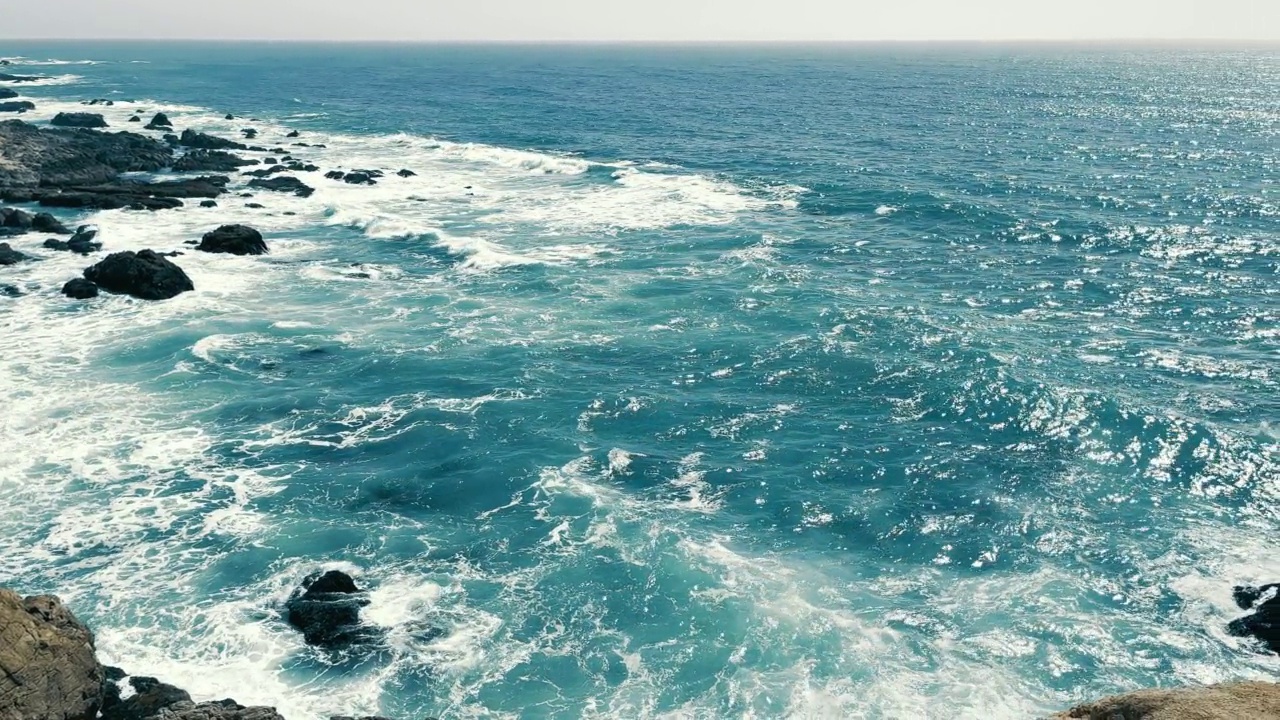 太平洋的岩石海岸。海浪冲击着岩石海岸。天气晴朗，还能看到美丽的海景。视频素材