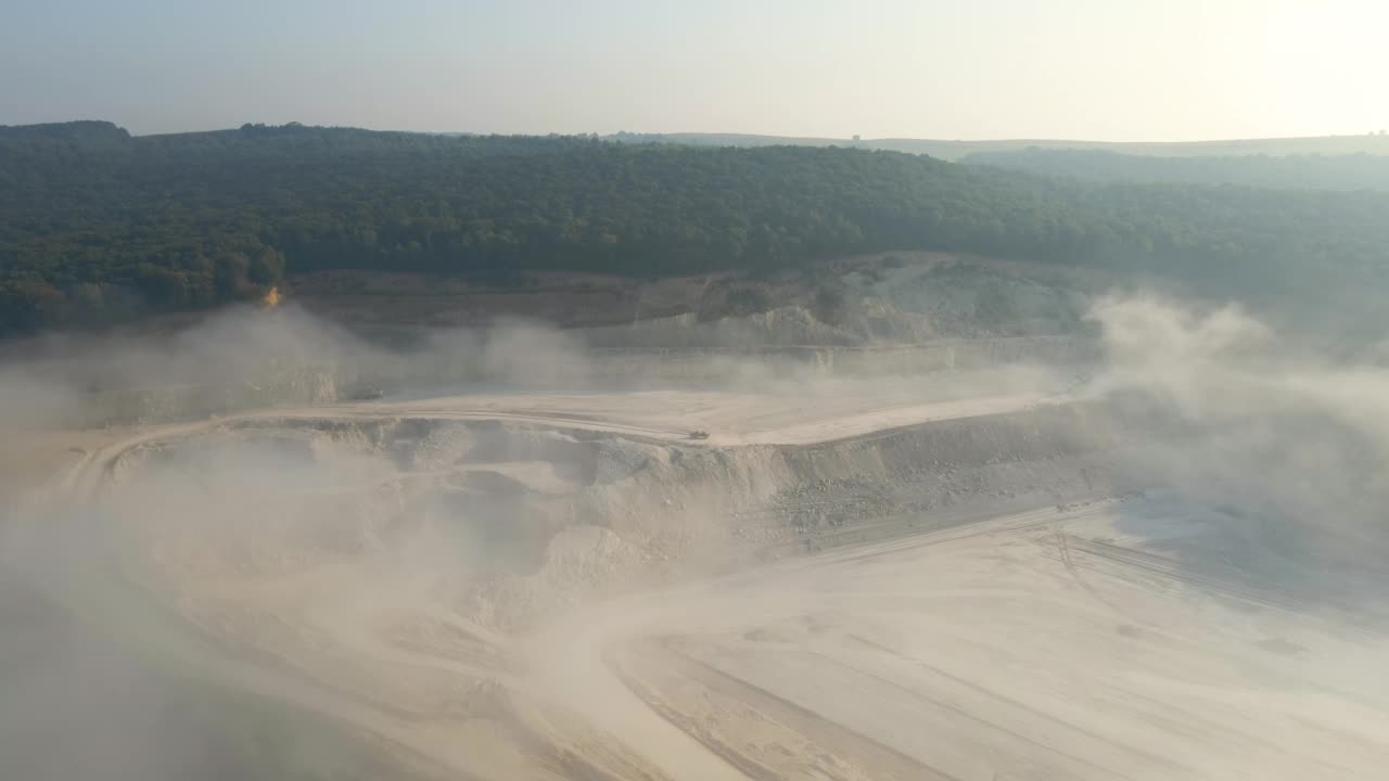 用挖掘机和自卸车露天开采建筑用石灰石材料的鸟瞰图视频素材