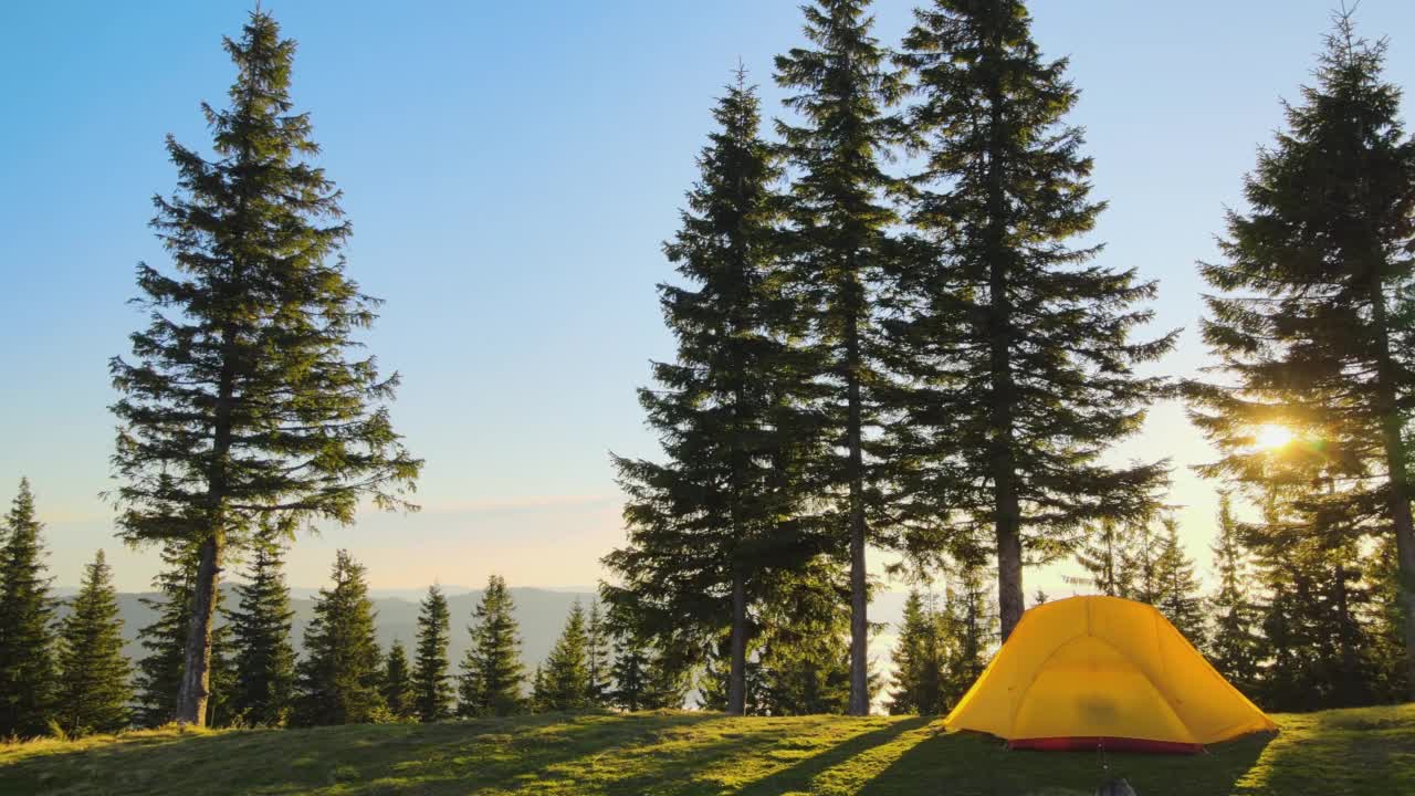 在阳光明媚的傍晚，游客在山间营地露营的鸟瞰图。积极的旅游和徒步概念视频素材