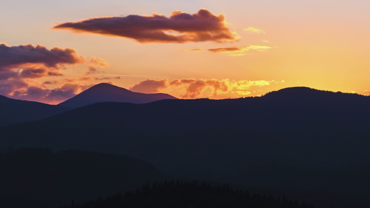 美丽的傍晚全景与明亮的夕阳在遥远的山峰在日落视频素材