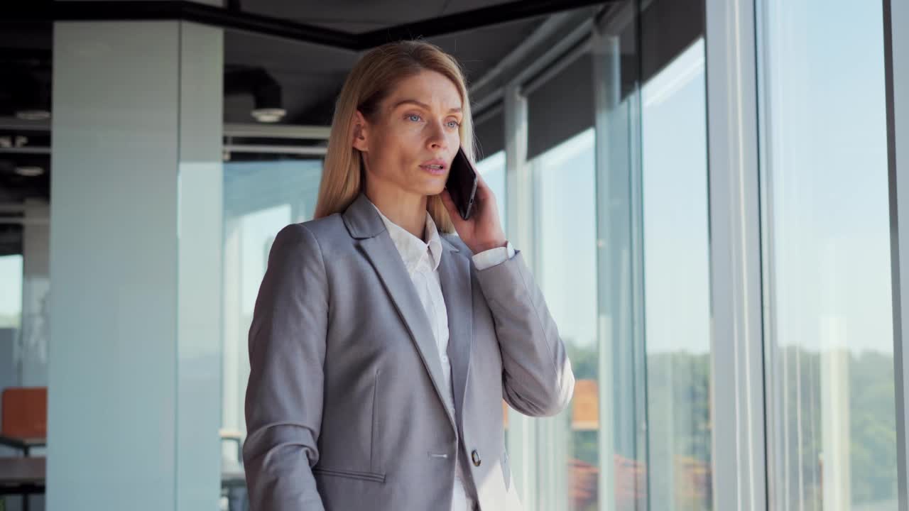 成功的公司女性领导者。严肃的女商人在办公室讲手机。自信的经理CEO肖像在室内用智能手机交谈。商界女性会解决这些问题。视频素材