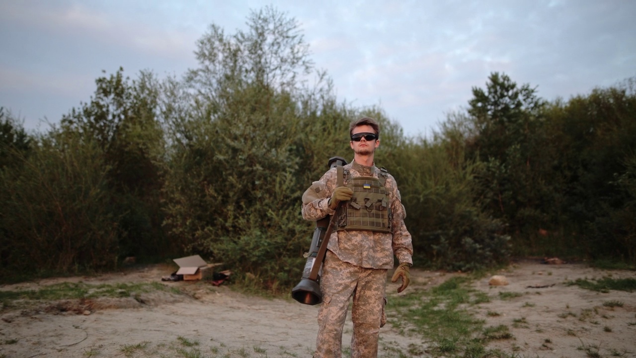 夕阳下，勇敢的美国陆军士兵兼教官手持反坦克武器在湖边行走视频素材