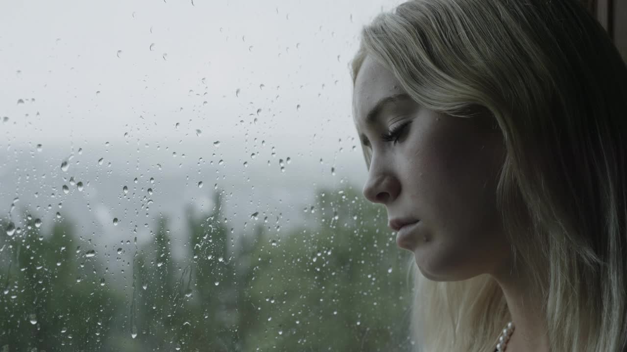 下雨天头靠在窗户上的抑郁少女/雪松山，犹他州，美国视频素材