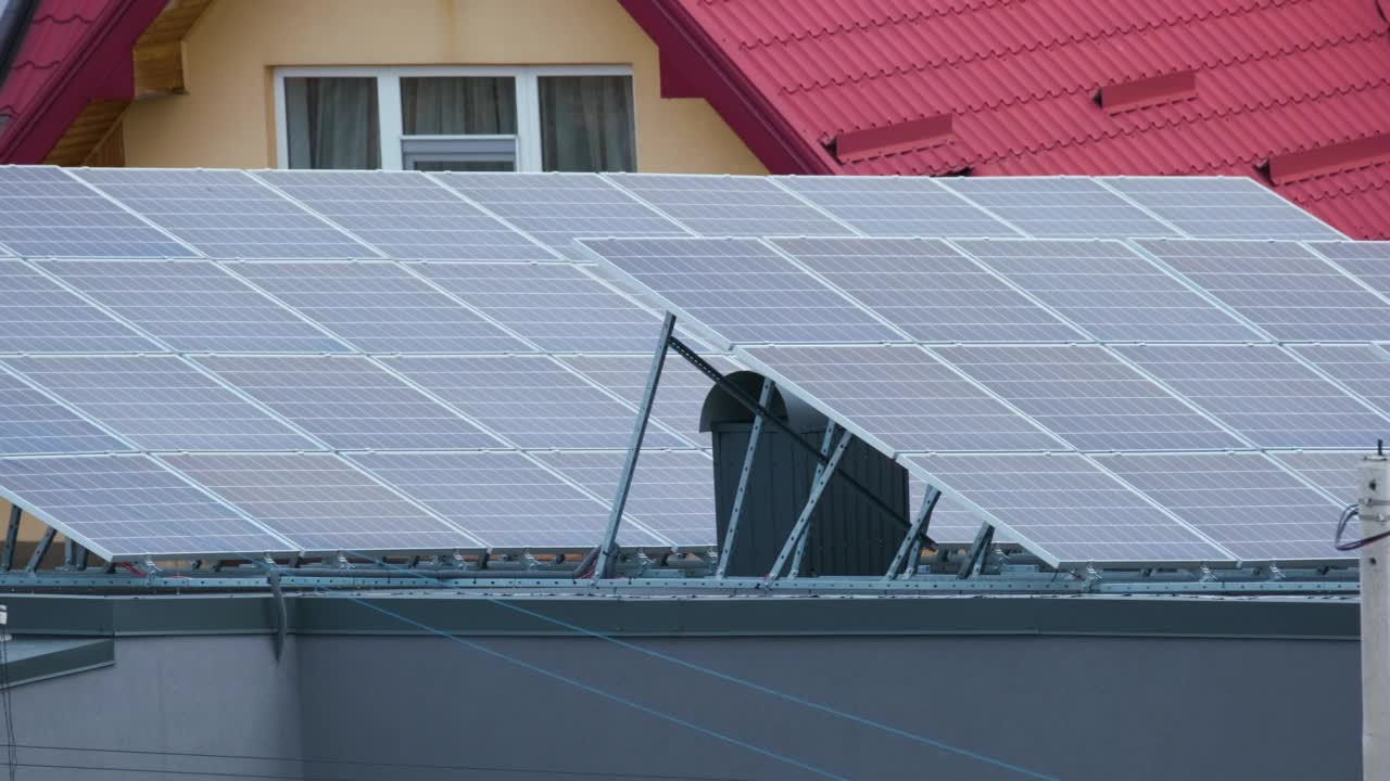 位于郊区农村的屋顶覆盖太阳能光伏板的住宅，用于生产清洁的生态电能。自主家居的概念视频素材