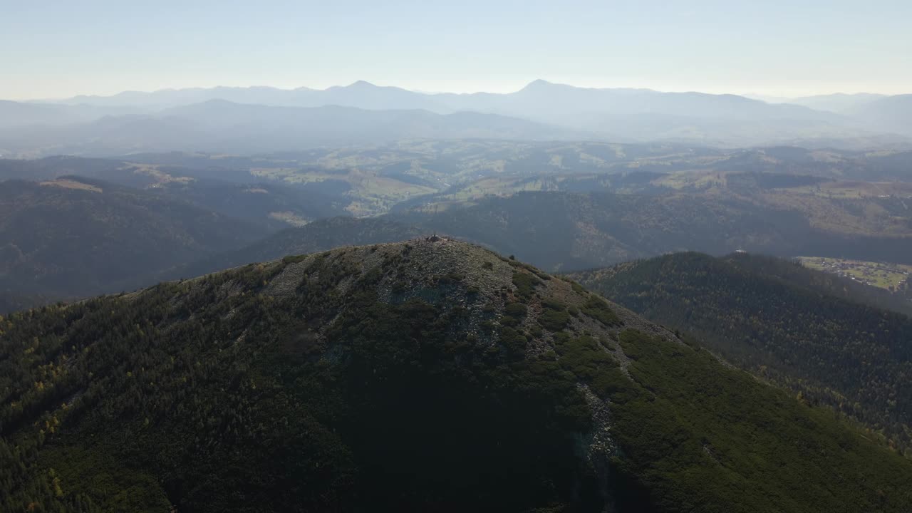 野生山脉中深色松树林的高山峰鸟瞰图视频素材