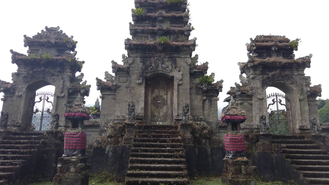 dolly拍摄的古老的巴厘岛寺庙与传统建筑位于坦布林安湖的stock footage视频下载