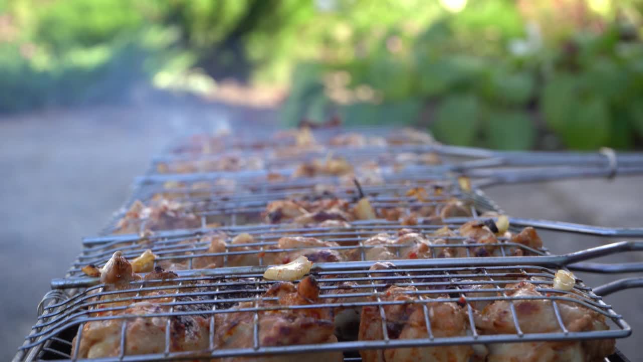 烧烤的特写，三只五香鸡腿放在闷烧的煤球上。烟熏烧烤配烤鸡肉。视频素材