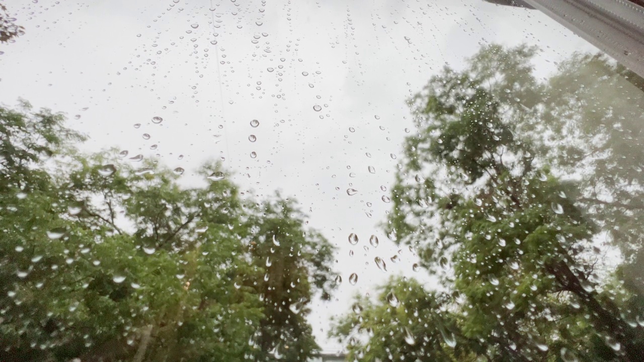 透过玻璃看，雨天，雨滴落在玻璃上。视频素材