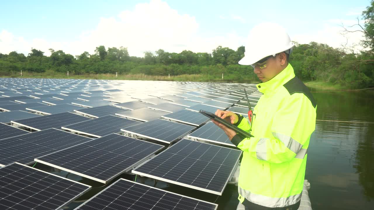 一名亚洲男性工程师在浮动太阳能电池板上工作。视频素材