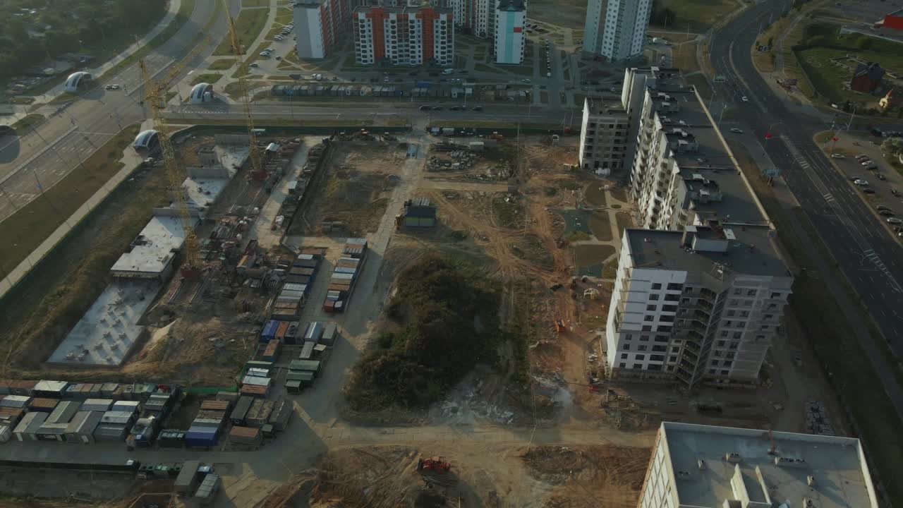 新城市街区的建筑工地。多层建筑的建造。建筑工地上的黎明。航空摄影。在太阳的背光下飞行视频素材