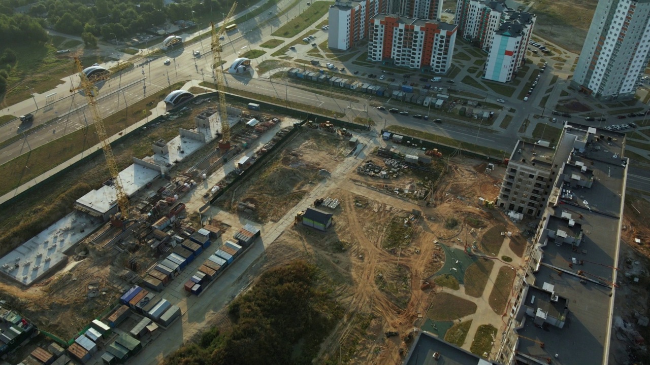 新城市街区的建筑工地。多层建筑的建造。建筑工地上的黎明。航空摄影。在太阳的背光下飞行。视频素材