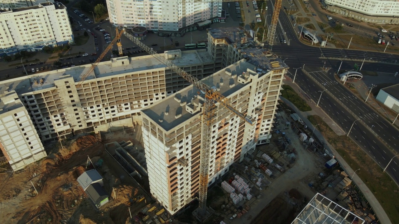 新城市街区的建筑工地。多层建筑的建造。建筑工地上的黎明。航空摄影。绕圈飞行。视频素材