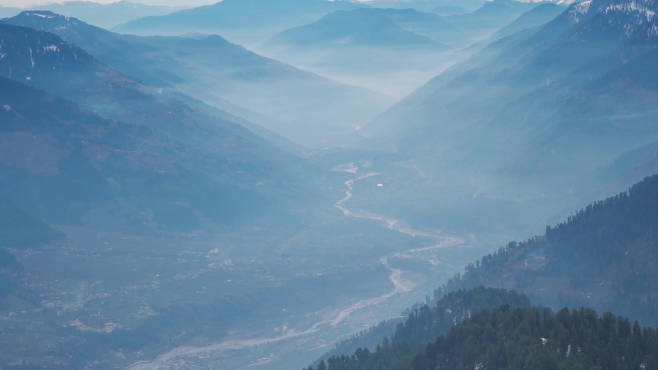 在Rani Sui湖徒步旅行期间，从山上看到的河流在山之间流过Kullu山谷的景观照片。从高处俯瞰山上河流的景色视频素材