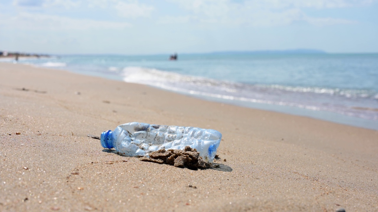 黑海沙滩上的空塑料瓶。塑料垃圾污染自然的概念。视频素材