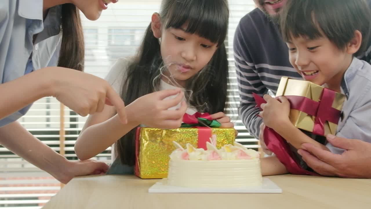 年幼的孩子们会为生日派对感到惊喜，并和家人一起庆祝。视频素材