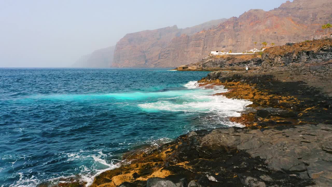 傍晚的大西洋，浪花翻滚在岩石海岸上。空中特写透明的蓝绿色风景如画的水撞击火山石，白色泡沫。非常美丽的巨石。视频素材