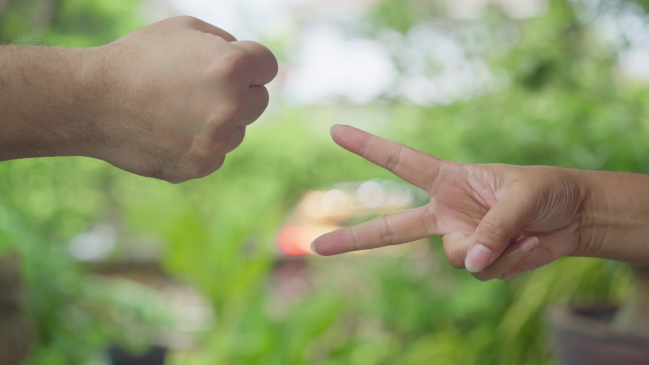 亚洲女人和男人的手玩石头剪刀布游戏。视频素材